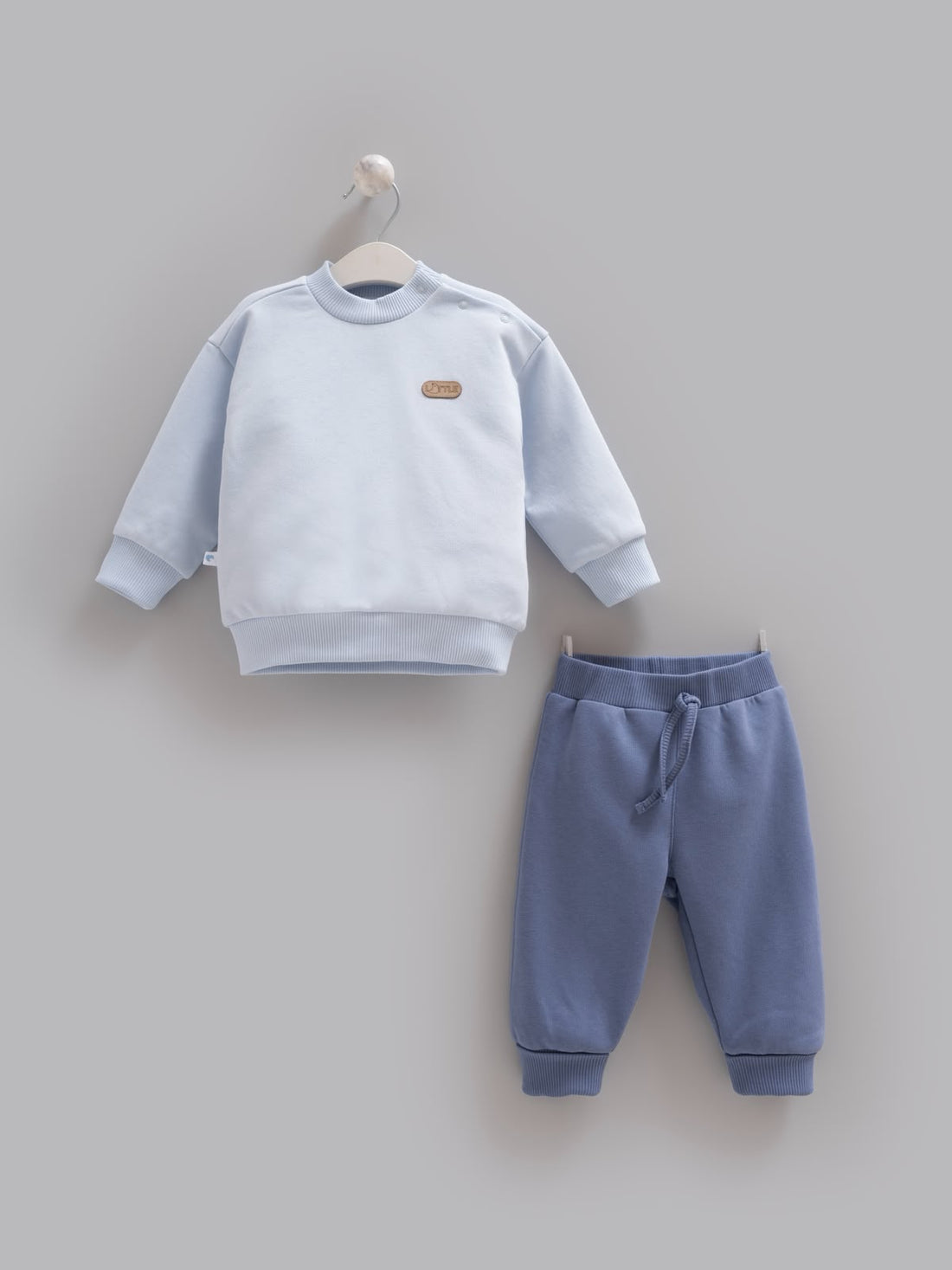 Açık mavi çıtçıtlı sweatshirt ve koyu mavi eşofman altından oluşan pamuklu 2’li erkek bebek takımı, 3–24 ay.